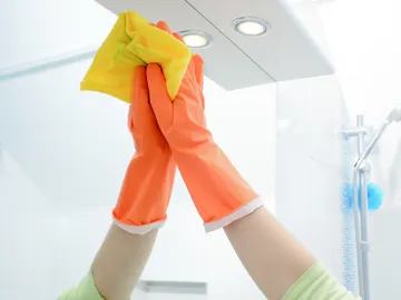 Primer plano de una mano limpiando un espejo Primer plano de una mano limpiando un espejo