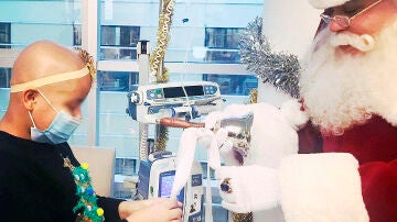 Fernando entrega una bolsa de regalos a una niña enferma