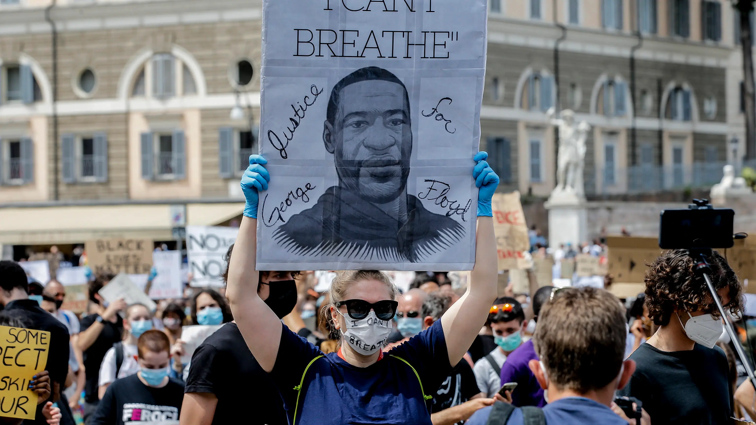 Imagen de archivo de personas con pancartas asisten a una manifestaci&oacute;n en memoria de George Floyd