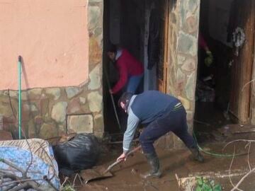 Vecinos de La Roca de la Sierra, retirando agua y barro de sus casas