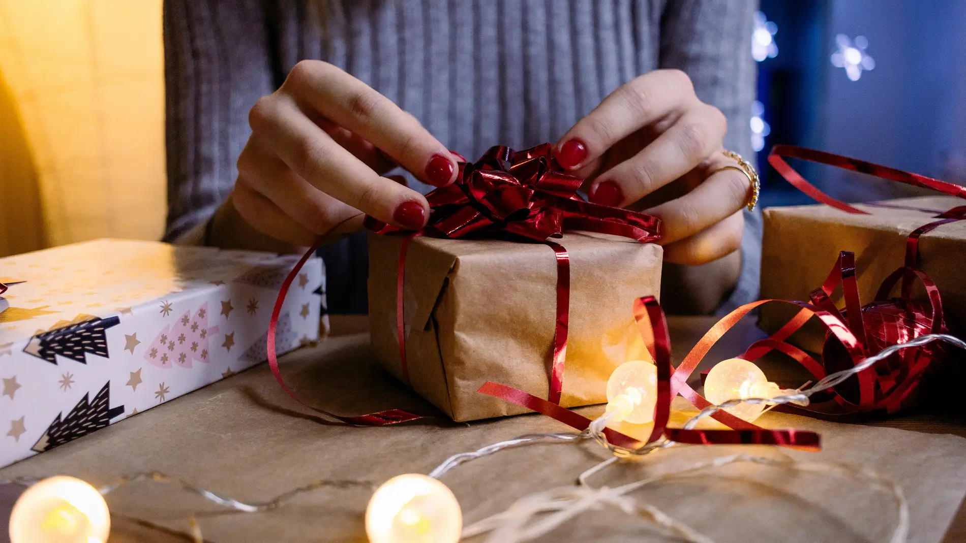 Primer plano de unas manos envolviendo un regalo