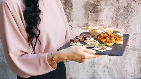 Mujer llevando una bandeja de canapés Mujer llevando una bandeja de canapés