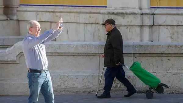 Un hombre camina con un carro de la compra Un hombre camina con un carro de la compra