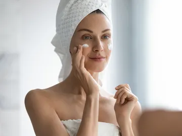 Mujer aplicándose una crema facial Mujer aplicándose una crema facial