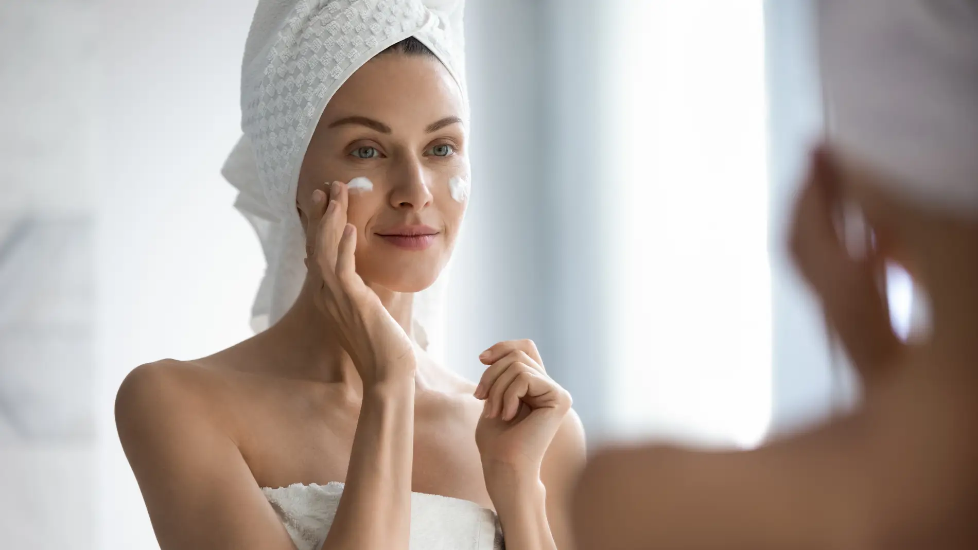 Mujer aplicándose una crema facial