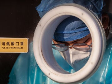 Un sanitario trabaja en una cabina para realizar PCR de coronavirus en Shanghái