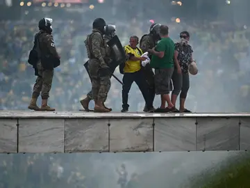 Policías enfrentan a seguidores del expresidente brasileño Jair Bolsonaro Policías enfrentan a seguidores del expresidente brasileño Jair Bolsonaro