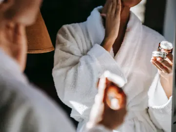 Mujer poniéndose una crema cosmética Mujer poniéndose una crema cosmética