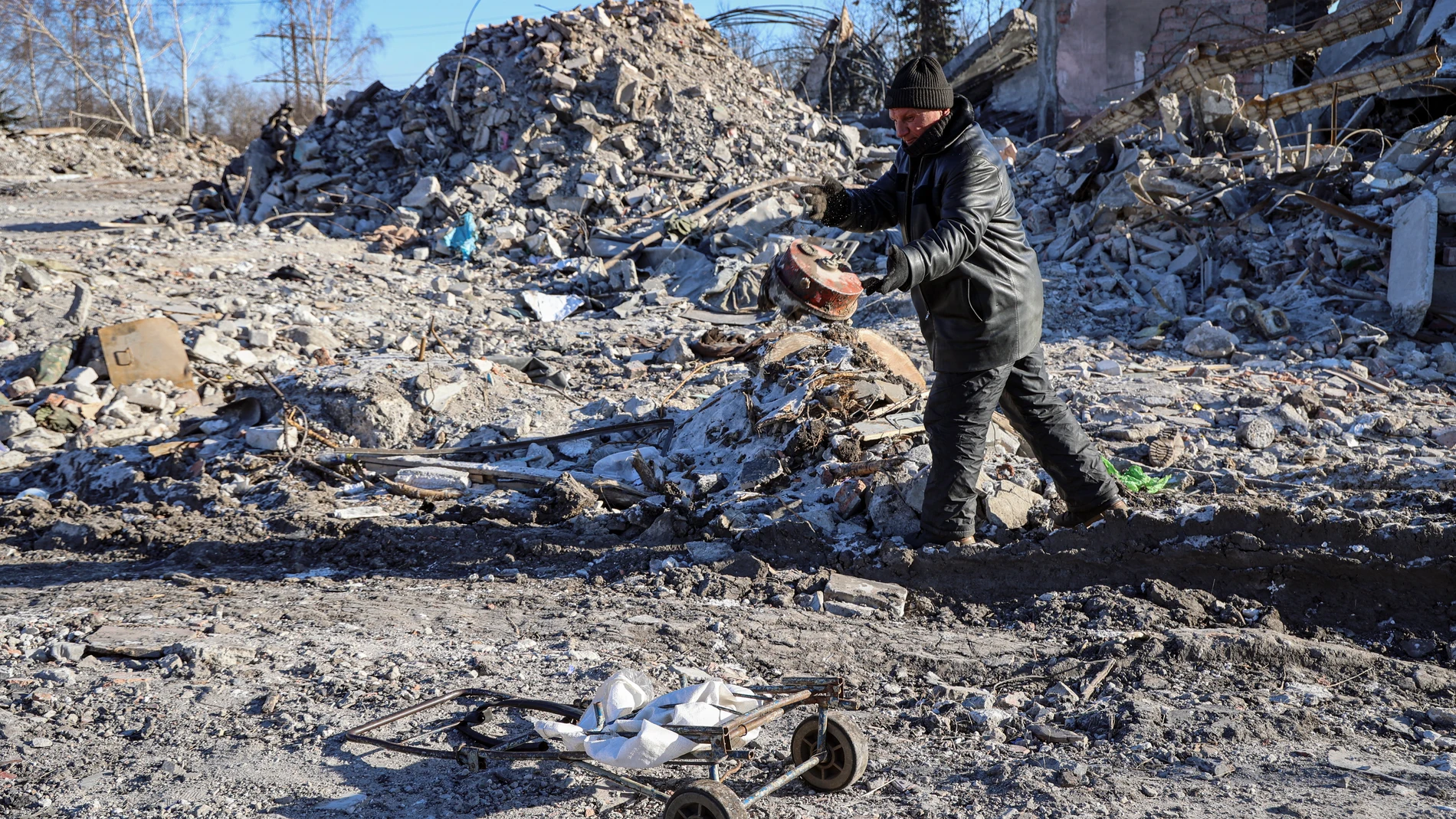 Un hombre despeja los escombros de una escuela vocacional que los militares rusos usaban como cuartel, en Makiivka, en la región de Donetskde paz
