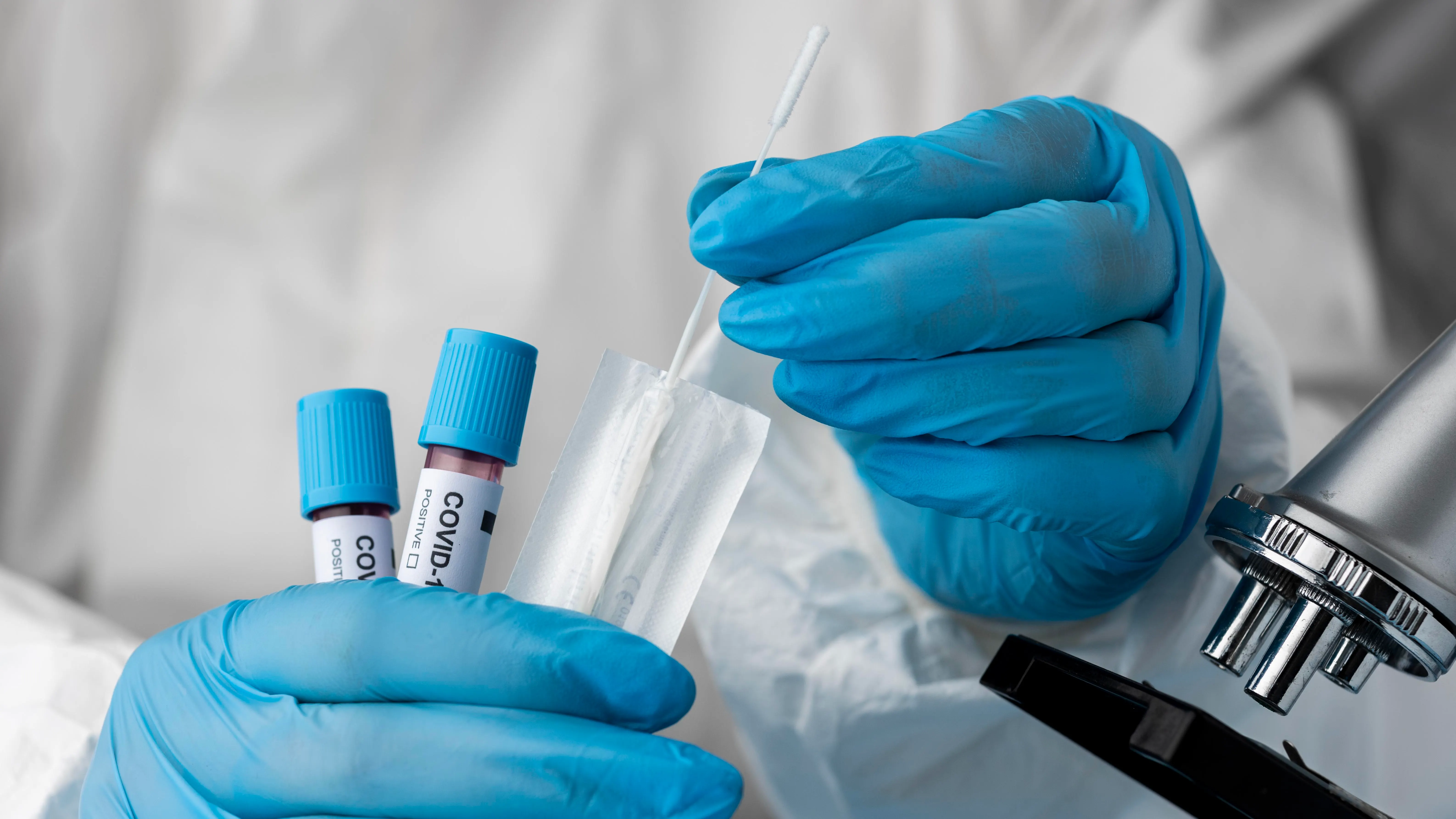 Un m&eacute;dico analiza una muestra de covid 