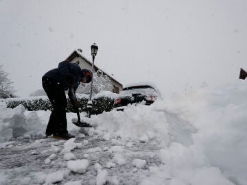 Una persona intenta limpiar la nieve en Navarra