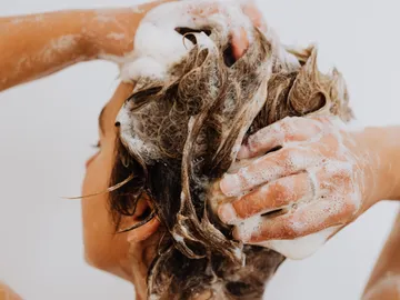 Mujer lavándose el pelo en la ducha Mujer lavándose el pelo en la ducha