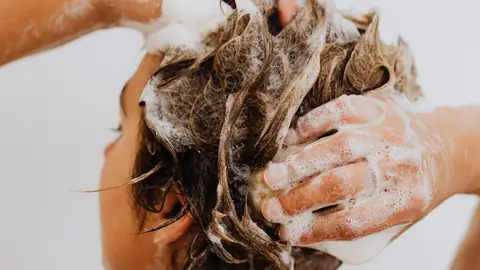 Mujer lavándose el pelo en la ducha Mujer lavándose el pelo en la ducha