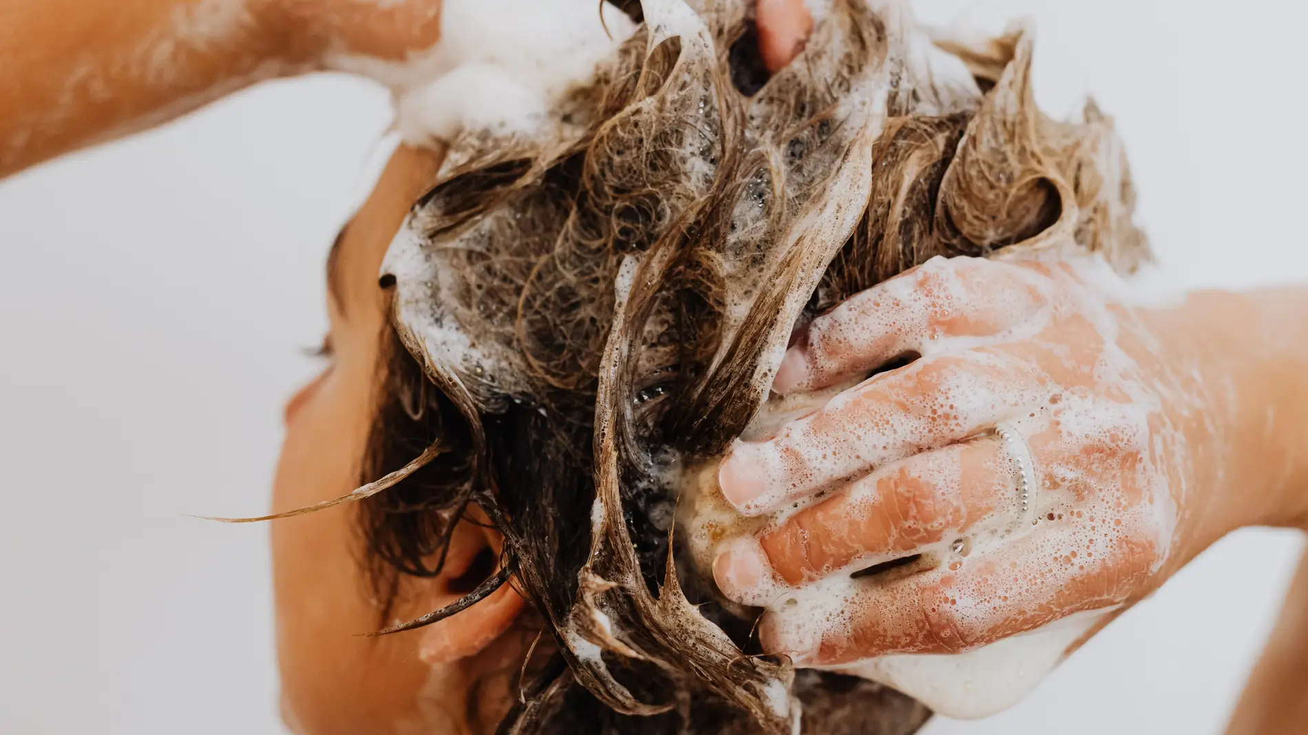 Mujer lavándose el pelo en la ducha