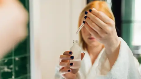 Mujer aplicándose un sérum Mujer aplicándose un sérum