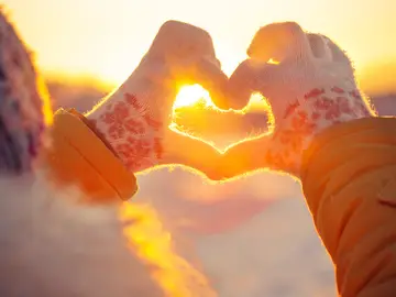 Joven haciendo un corazón con los dedos en invierno Joven haciendo un corazón con los dedos en invierno