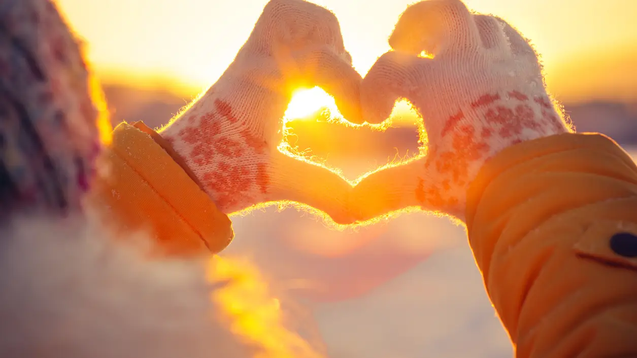 Joven haciendo un corazón con los dedos en invierno Joven haciendo un corazón con los dedos en invierno