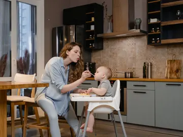 Una madre da de comer a su bebé. Una madre da de comer a su bebé.