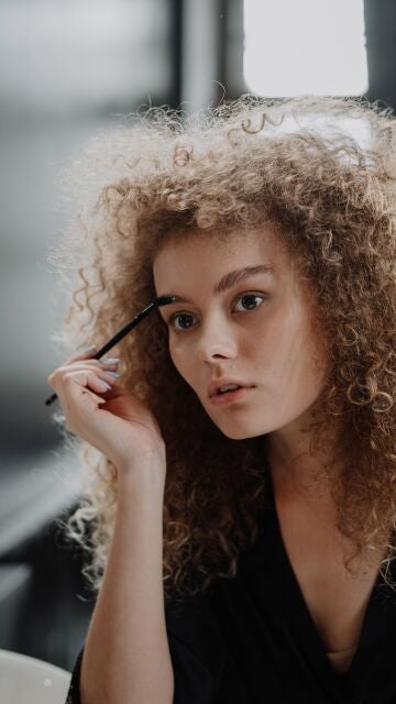 Joven peinándose las cejas