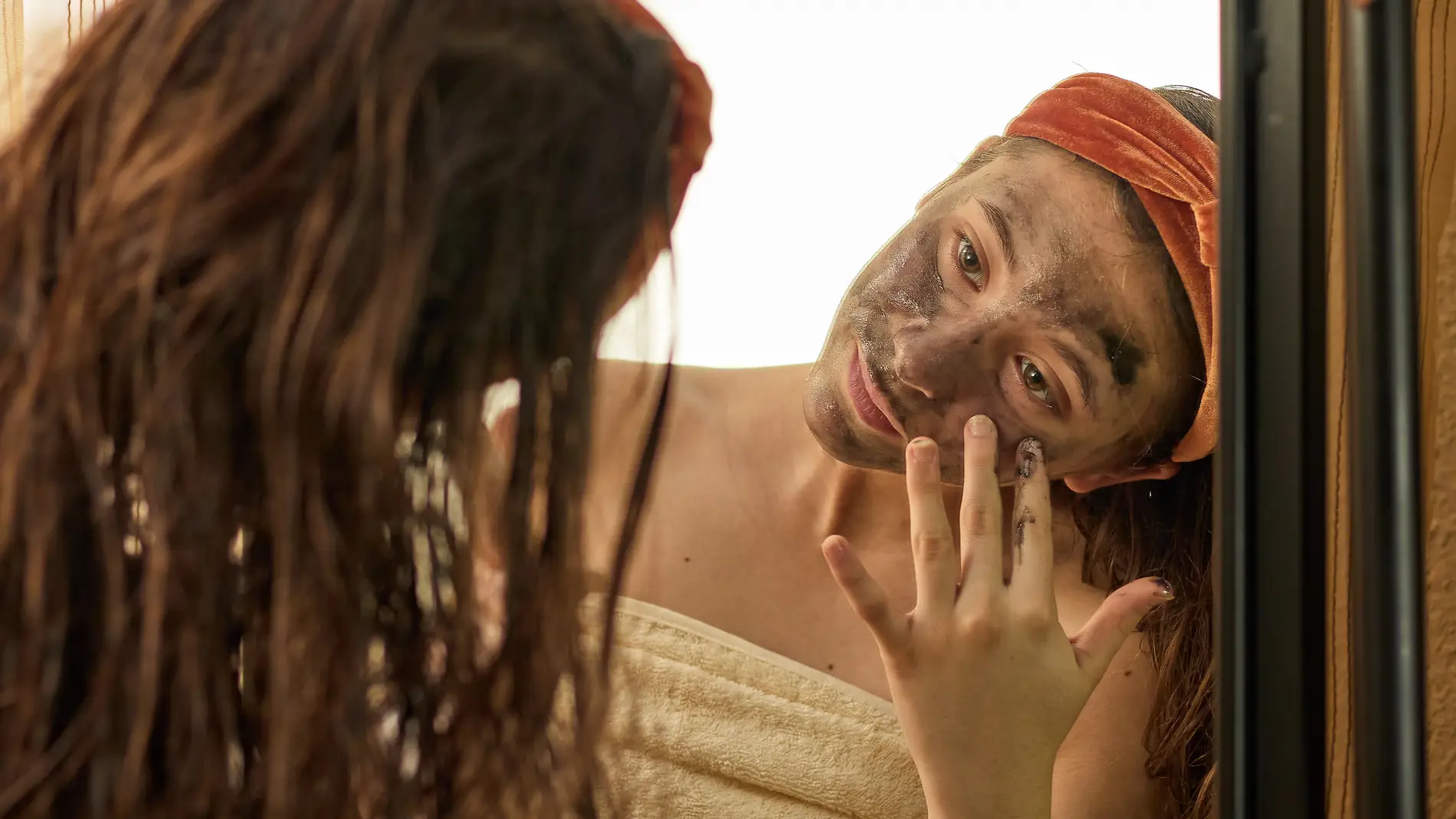 Chica aplicándose una mascarilla facial