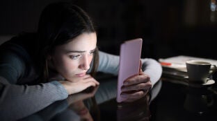 Imagen de una joven preocupada mirando el m&oacute;vil
