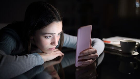 Imagen de una joven preocupada mirando el m&oacute;vil