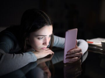 Imagen de una joven preocupada mirando el móvil