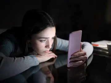 Imagen de una joven preocupada mirando el móvil Imagen de una joven preocupada mirando el móvil