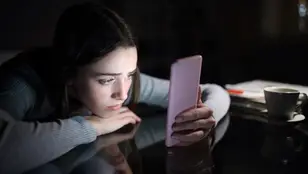 Imagen de una joven preocupada mirando el móvil