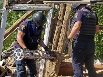 Dos policías inspeccionan un misil ruso en suelo ucraniano Dos policías inspeccionan un misil ruso en suelo ucraniano