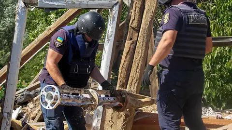 Dos policías inspeccionan un misil ruso en suelo ucraniano Dos policías inspeccionan un misil ruso en suelo ucraniano