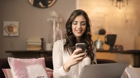 Mujer consultando el teléfono móvil Mujer consultando el teléfono móvil