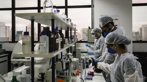 Se cura de VIH gracias a células madre de sangre de cordón umbilical Imagen de archivo de personas trabajando en una investigación sobre el VIH