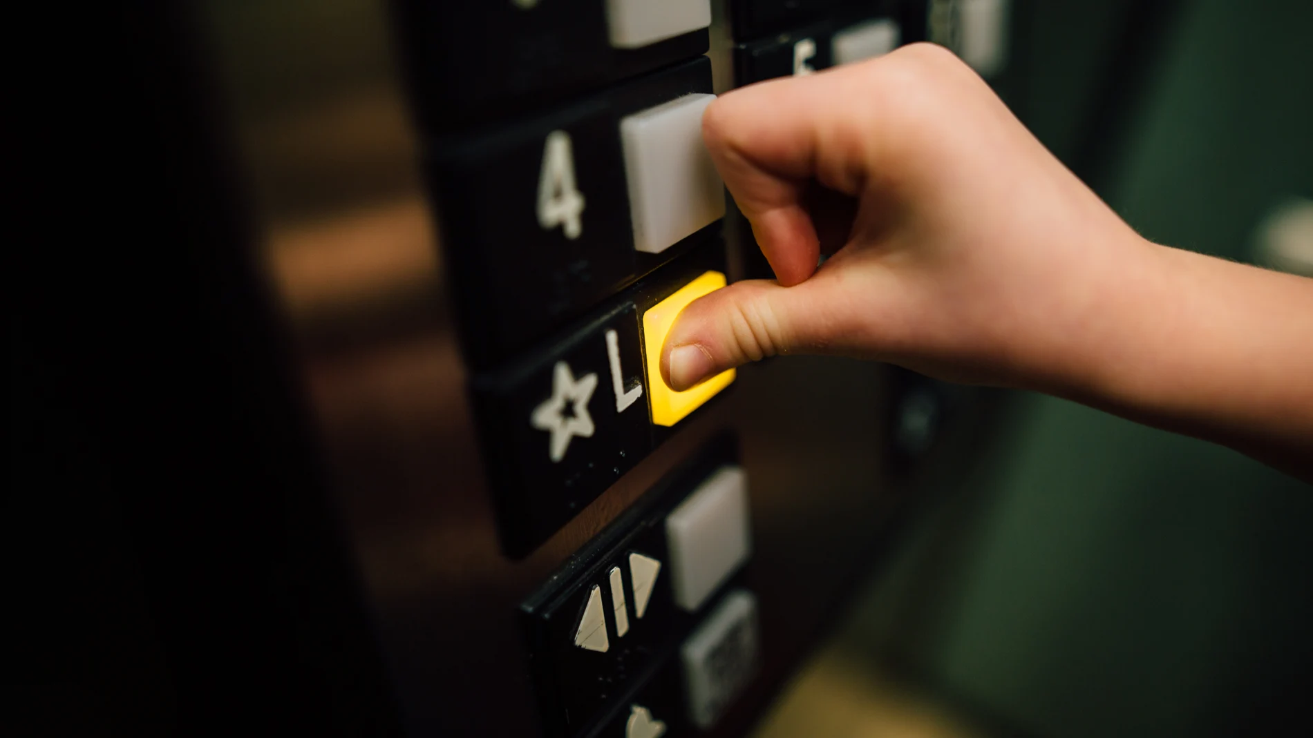Persona presiona el botón de un ascensor