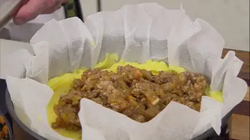Cubre la base del molde con la mitad del puré de patata, reparte encima la carne