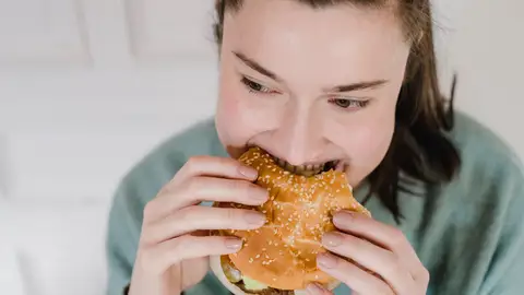 Una mujer come hamburguesa