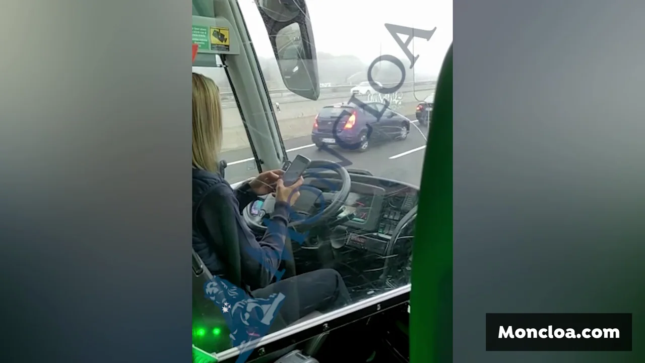 Una conductora de autobús utilizando el móvil mientras circula Una conductora de autobús utilizando el móvil mientras circula