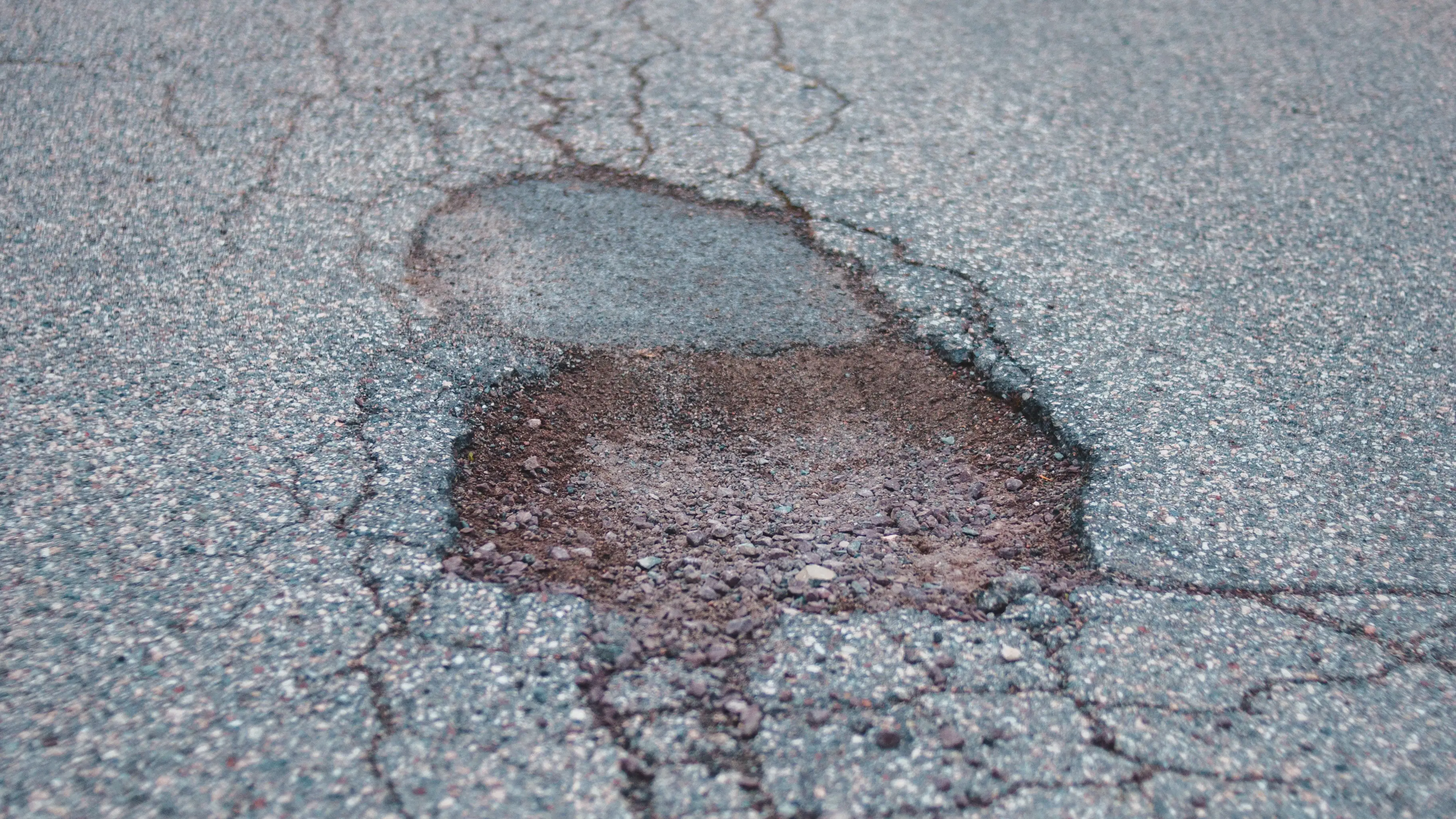 Imagen de archivo de una carretera con baches Imagen de archivo de una carretera con baches