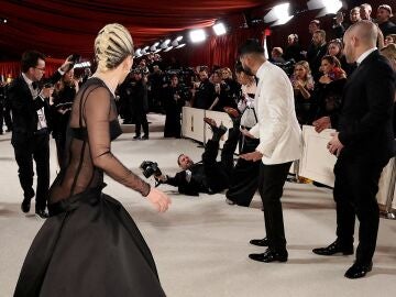 Lady Gaga ayuda a un fotógrafo en la alfombra roja de los Oscar