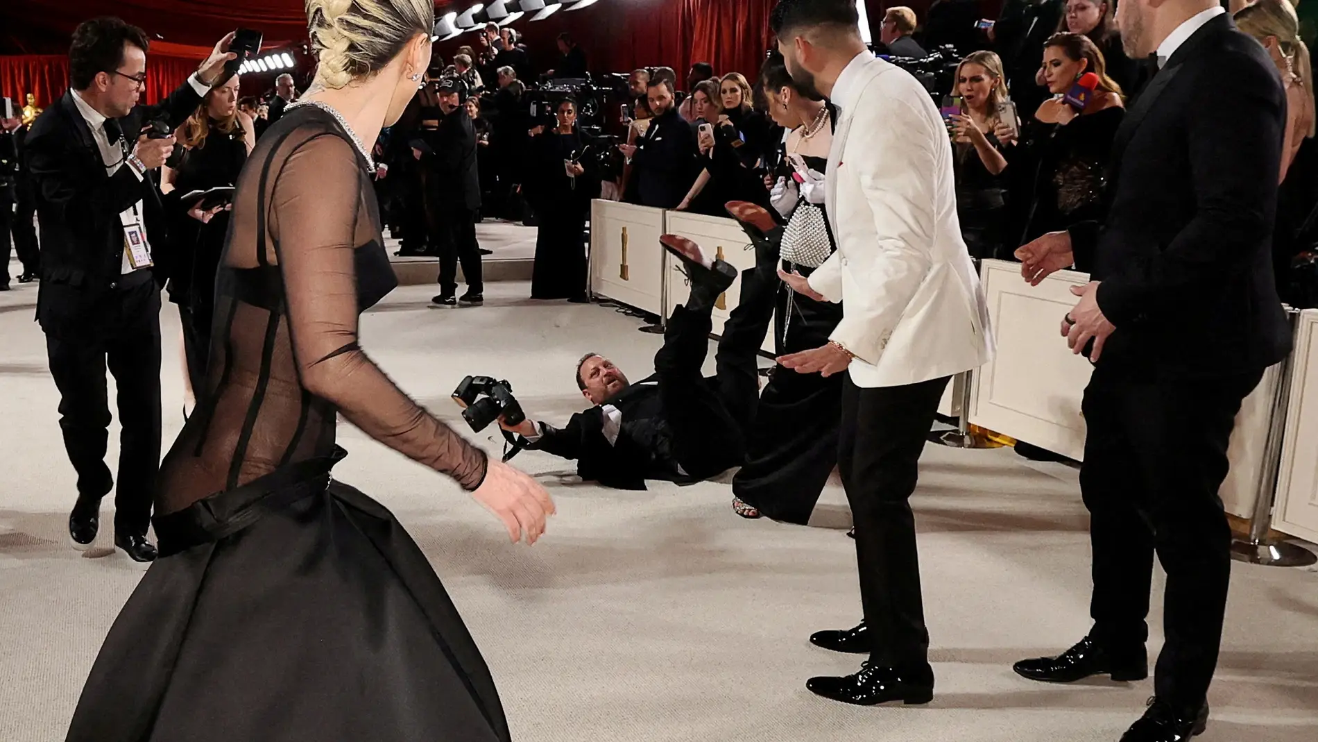Lady Gaga ayuda a un fotógrafo en la alfombra roja de los Oscar