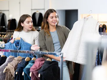 Chicas comprando chalecos en una tienda Chicas comprando chalecos en una tienda