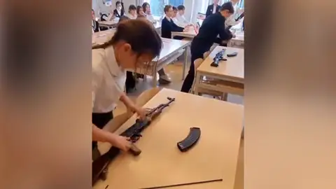 Una niña aprende a montar un fusil en un colegio Armas
