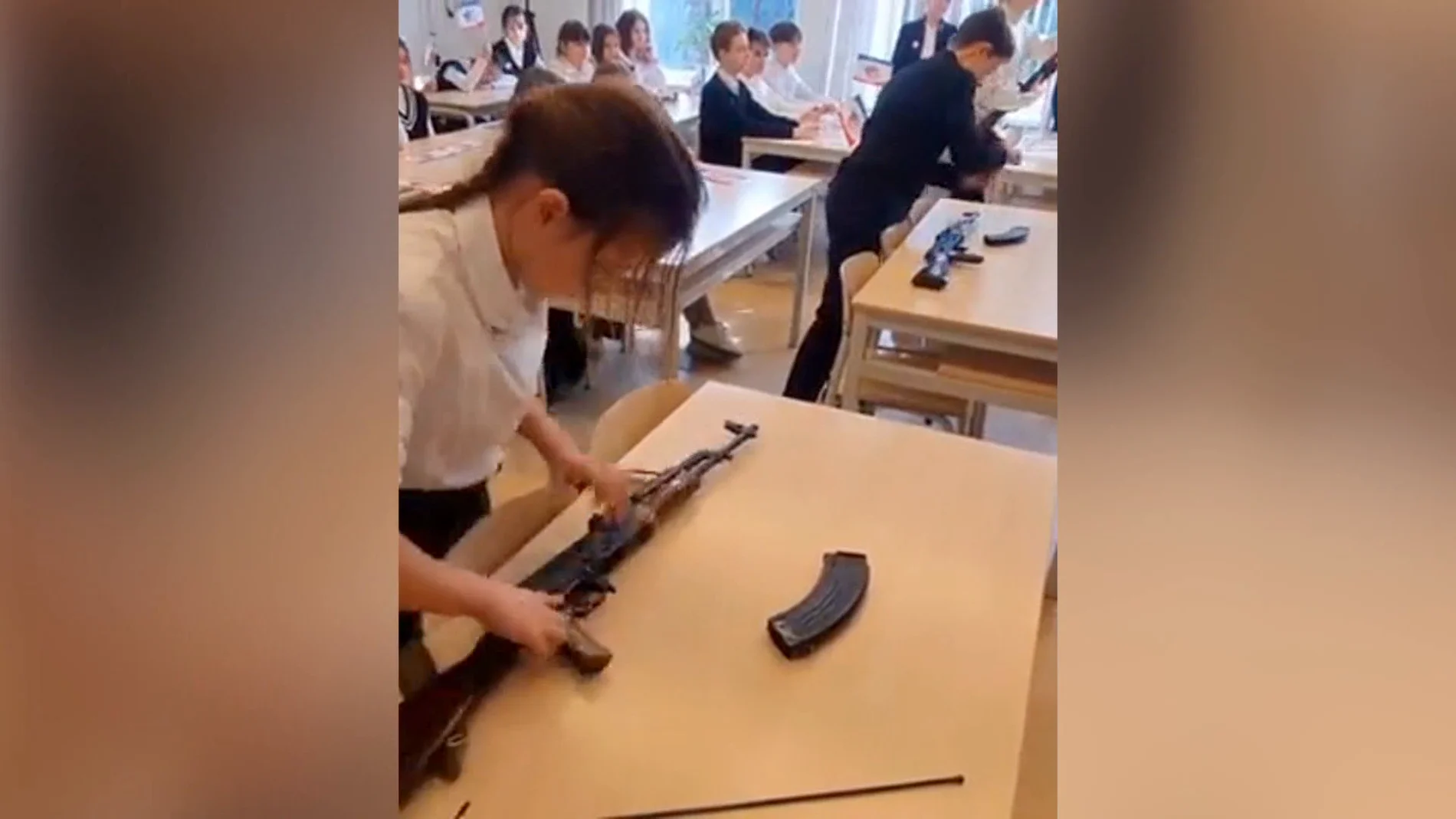 Una niña aprende a montar un fusil en un colegio