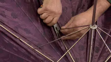 Una persona arreglando un paraguas
