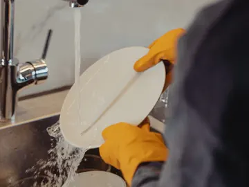 Persona lavando platos Persona lavando platos