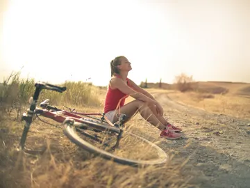 Una mujer descansa de un paseo en bicicleta Una mujer descansa de un paseo en bicicleta