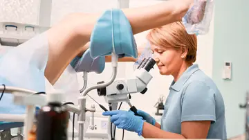 Ginecóloga realizando un examen pélvico Ginecóloga realizando un examen pélvico