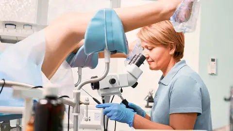 Ginecóloga realizando un examen pélvico Ginecóloga realizando un examen pélvico