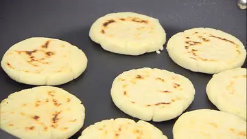 Extiende 4 arepas en la sartén y dóralas por los 2 lados