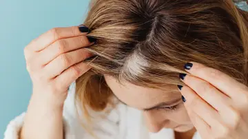 Mujer con canas mirándose al espejo Mujer con canas mirándose al espejo